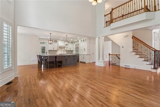 3115 Corsair Curv, Cumming, GA 30040 - living area with a towering ceiling, wood finished floors, stairway, a chandelier, and baseboards