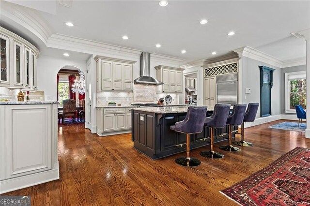 2120 Blackheath Trce, Alpharetta, GA 30005 - kitchen featuring wall chimney range hood, stainless steel built in refrigerator, crown molding, arched walkways, and backsplash