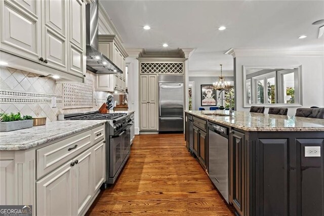 2120 Blackheath Trce, Alpharetta, GA 30005 - kitchen with high quality appliances, wall chimney range hood, ornamental molding, a chandelier, and an island with sink