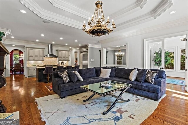 2120 Blackheath Trce, Alpharetta, GA 30005 - living area with a chandelier, dark wood-type flooring, ornamental molding, arched walkways, and a raised ceiling