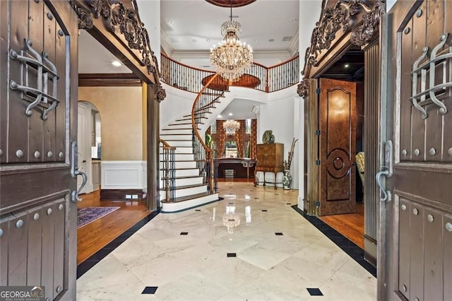 2120 Blackheath Trce, Alpharetta, GA 30005 - entryway featuring arched walkways, crown molding, stairway, wainscoting, and a chandelier
