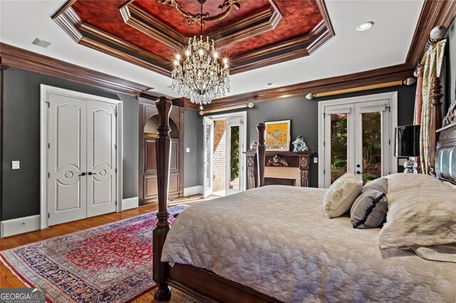 2120 Blackheath Trce, Alpharetta, GA 30005 - bedroom with access to exterior, a raised ceiling, french doors, wood finished floors, and a chandelier