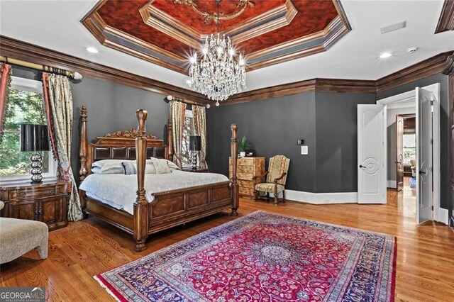 2120 Blackheath Trce, Alpharetta, GA 30005 - bedroom featuring multiple windows, a chandelier, a tray ceiling, wood finished floors, and ornamental molding