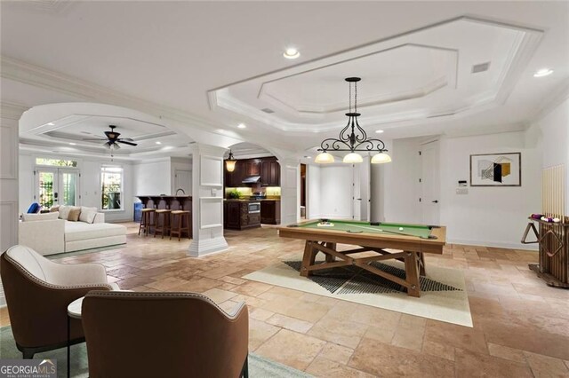 2120 Blackheath Trce, Alpharetta, GA 30005 - playroom featuring a raised ceiling, decorative columns, stone tile floors, arched walkways, and crown molding