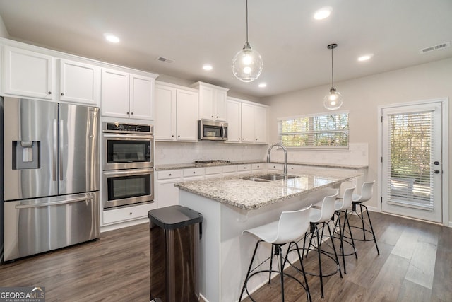 810 Relic Rdg, Hampton, GA 30228 - kitchen featuring appliances with stainless steel finishes, tasteful backsplash, a sink, and dark wood-type flooring