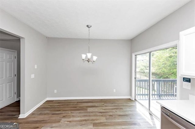 unfurnished dining area featuring light wood-type flooring, baseboards, and a notable chandelier