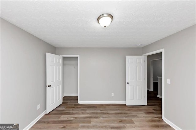 unfurnished bedroom with baseboards and wood finished floors