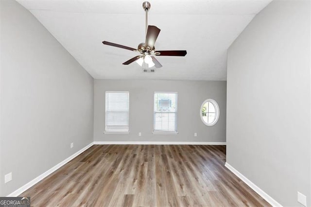 unfurnished room featuring wood finished floors, visible vents, a ceiling fan, and baseboards