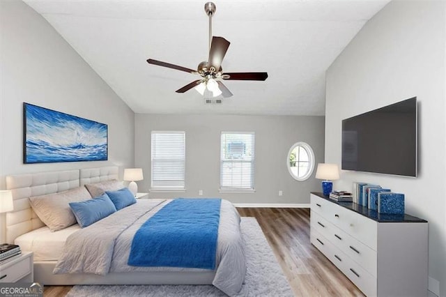 bedroom with lofted ceiling, visible vents, baseboards, light wood-style flooring, and ceiling fan
