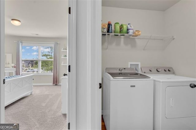 laundry area with baseboards, washing machine and clothes dryer, light colored carpet, and laundry area