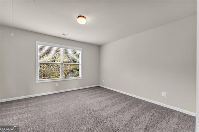 carpeted empty room featuring visible vents and baseboards