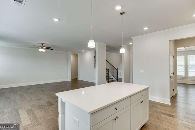 7208 Whitewater Dr, Flowery Branch, GA 30542 - kitchen featuring ornamental molding, a ceiling fan, a kitchen island, decorative light fixtures, and light countertops
