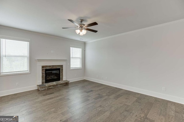 7208 Whitewater Dr, Flowery Branch, GA 30542 - unfurnished living room with dark wood-style flooring, a ceiling fan, ornamental molding, and a stone fireplace
