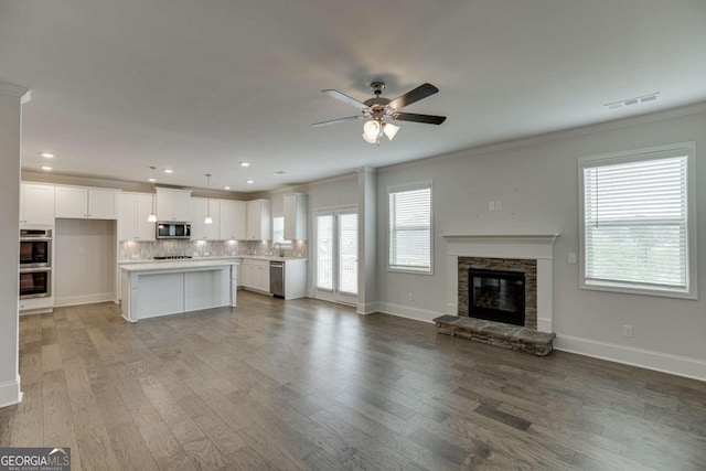 7208 Whitewater Dr, Flowery Branch, GA 30542 - unfurnished living room with crown molding, ceiling fan, light wood-style floors, a fireplace, and recessed lighting