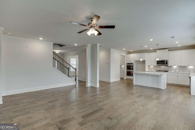 7208 Whitewater Dr, Flowery Branch, GA 30542 - unfurnished living room featuring light wood-style floors, ceiling fan, ornamental molding, and recessed lighting