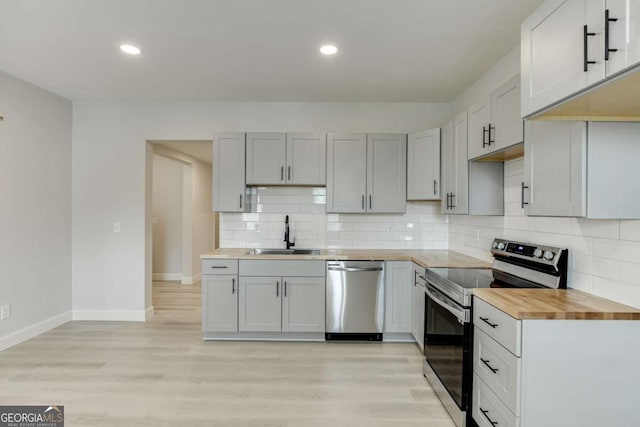 7208 Whitewater Dr, Flowery Branch, GA 30542 - kitchen with appliances with stainless steel finishes, wooden counters, decorative backsplash, light wood-type flooring, and recessed lighting