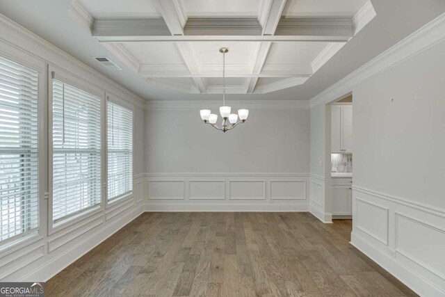 7208 Whitewater Dr, Flowery Branch, GA 30542 - unfurnished dining area featuring a chandelier, beamed ceiling, coffered ceiling, wood finished floors, and crown molding