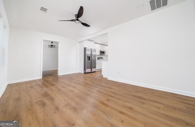 2215 Gordon Cir SE, Smyrna, GA 30080 - unfurnished living room featuring ceiling fan, baseboards, light wood-style floors, and visible vents
