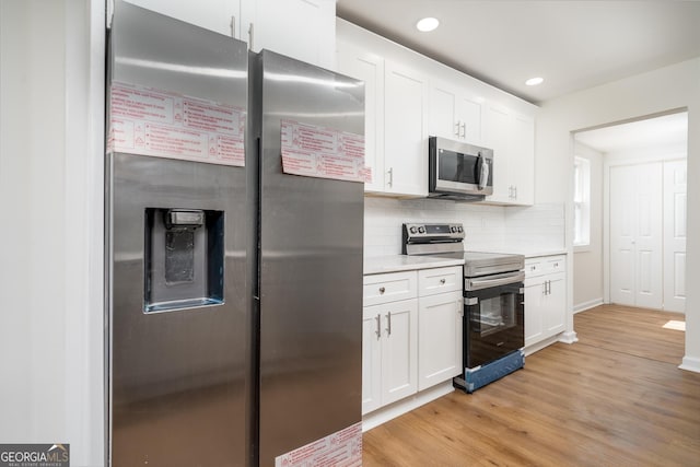 2215 Gordon Cir SE, Smyrna, GA 30080 - kitchen with stainless steel appliances, light wood finished floors, light countertops, backsplash, and white cabinetry