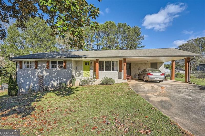 ranch-style house featuring concrete driveway, an attached carport, a front yard, and brick siding