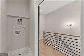 clothes washing area featuring laundry area, hookup for a washing machine, and baseboards