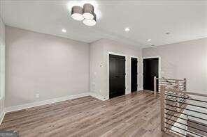 empty room with baseboards, recessed lighting, and wood finished floors