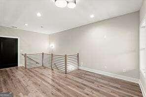 unfurnished room featuring recessed lighting, baseboards, and wood finished floors