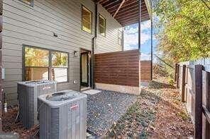 view of property exterior featuring fence and central AC unit