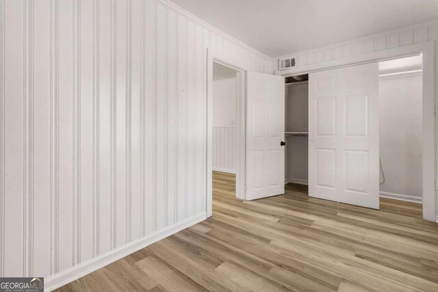 3556 Finch Rd SW, Powder Springs, GA 30127 - unfurnished bedroom with light wood-style floors, a closet, ornamental molding, and baseboards