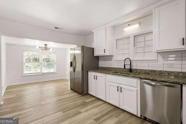 3556 Finch Rd SW, Powder Springs, GA 30127 - kitchen with appliances with stainless steel finishes, a sink, backsplash, and white cabinets