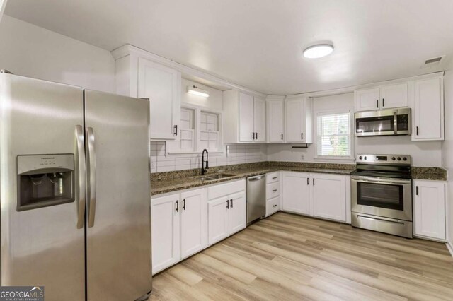 3556 Finch Rd SW, Powder Springs, GA 30127 - kitchen featuring appliances with stainless steel finishes, a sink, white cabinets, and light wood-type flooring