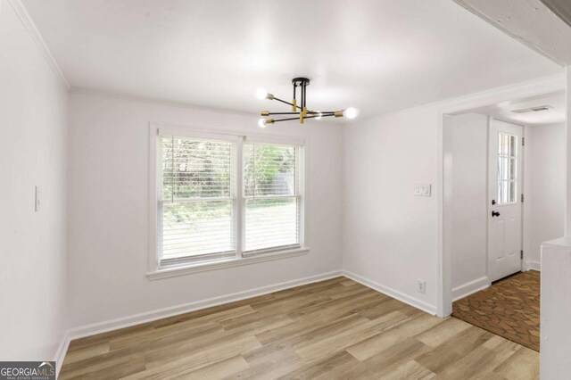 3556 Finch Rd SW, Powder Springs, GA 30127 - empty room featuring a chandelier, light wood-type flooring, crown molding, and baseboards