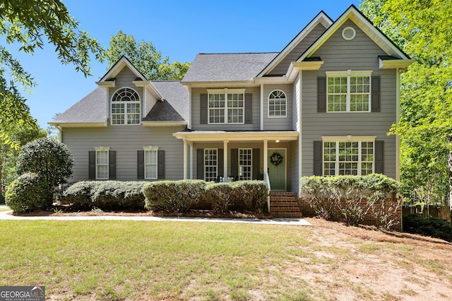 traditional home with covered porch and a front yard