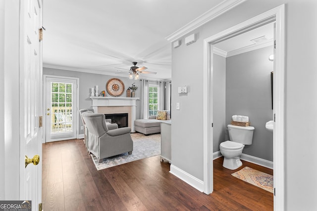 living area with ceiling fan, ornamental molding, wood finished floors, and plenty of natural light