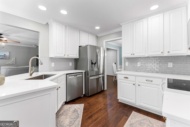 kitchen featuring white cabinets, stainless steel appliances, a sink, tasteful backsplash, and ornamental molding