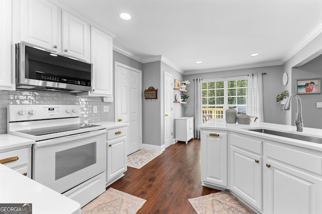 kitchen with a sink, white electric range, stainless steel microwave, ornamental molding, and recessed lighting