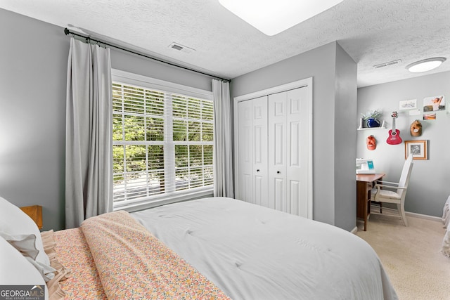 carpeted bedroom with baseboards, visible vents, and a textured ceiling