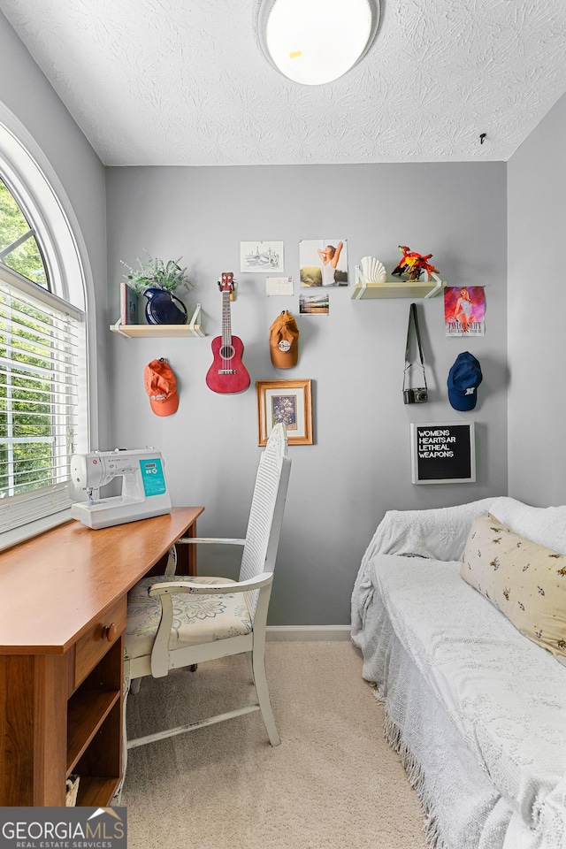 carpeted bedroom with a textured ceiling and baseboards