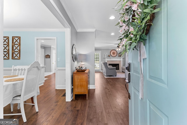 foyer featuring recessed lighting, dark wood-type flooring, crown molding, a fireplace, and ceiling fan
