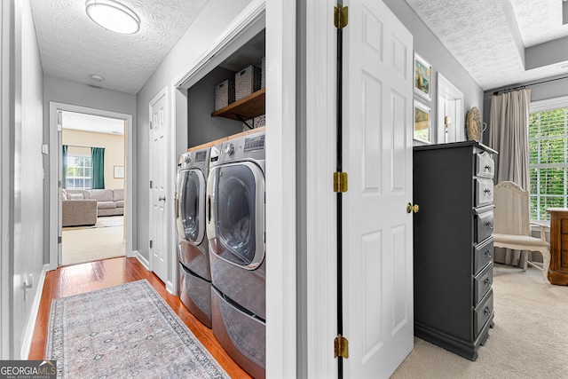 washroom featuring baseboards, a textured ceiling, laundry area, and independent washer and dryer