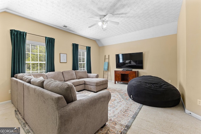 carpeted living room with vaulted ceiling, visible vents, a ceiling fan, and baseboards