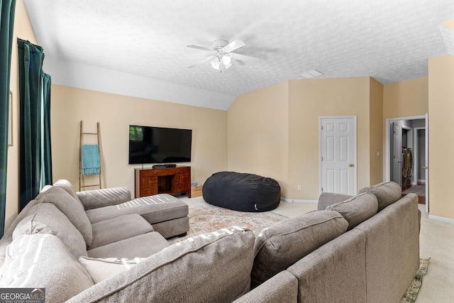 living area with light colored carpet, baseboards, a ceiling fan, and a textured ceiling
