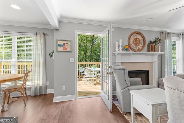 interior space with wood finished floors, a fireplace, baseboards, ornamental molding, and recessed lighting