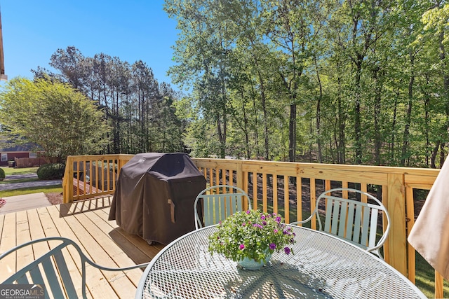 wooden deck featuring outdoor dining area and grilling area