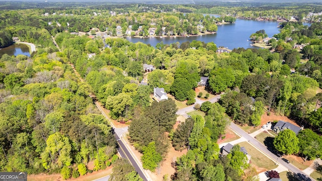 aerial view with a water view and a wooded view