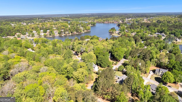 bird's eye view featuring a wooded view and a water view
