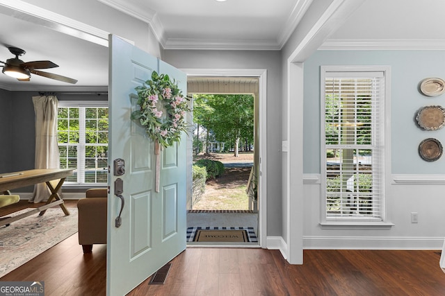 doorway with ceiling fan, visible vents, ornamental molding, baseboards, and dark wood-style flooring