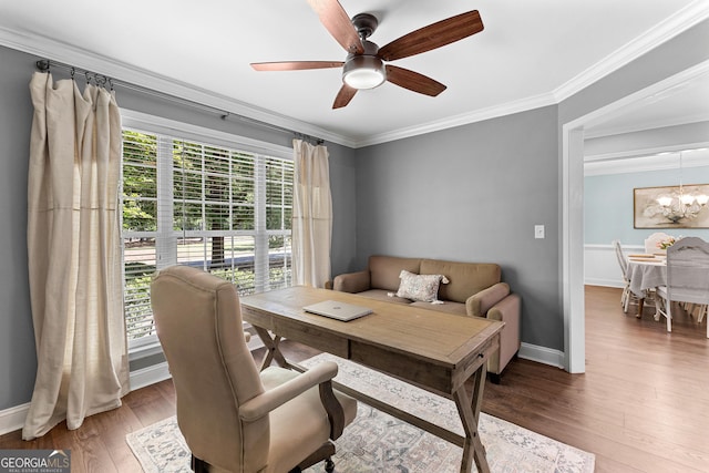 office area featuring wood finished floors, baseboards, ornamental molding, and ceiling fan with notable chandelier