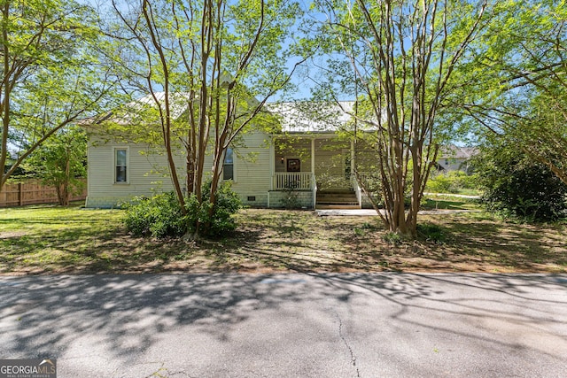view of front of property with fence, crawl space, and covered porch