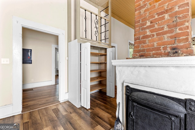 unfurnished living room featuring a fireplace, baseboards, visible vents, and dark wood-style floors